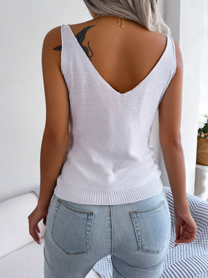 White cable knit diamond vest top with V-neck and ribbed hem.