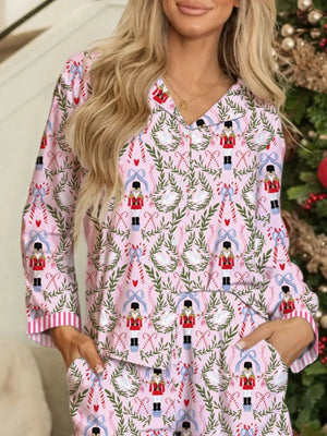 Pink button-down pajama set with nutcracker, swan, and candy cane print.