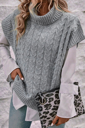 Gray cable knit turtleneck capelet sweater with short sleeves, styled with a white shirt and leopard clutch.