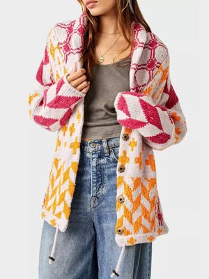 Geometric patchwork knit cardigan with button front and drawstring hem. Features pink, orange, and white patterns.