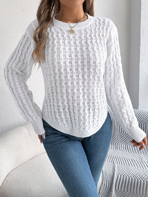 White cable knit sweater with asymmetric hem and crew neck, acrylic material.