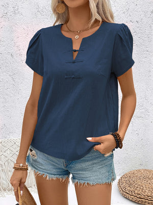 Indigo linen blouse with mandarin collar, puff sleeves, and knot button detail.