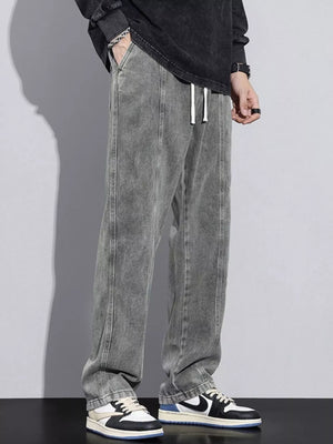 Comfortable relaxed fit jeans in grey denim with white drawstring and vertical seam detail.