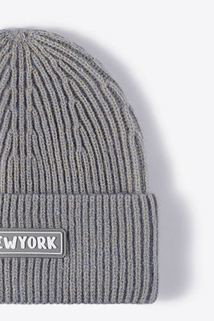 Gray ribbed acrylic beanie with a New York patch detail.