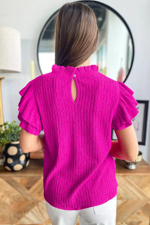 Textured ruffle trim blouse with mock neck and keyhole back.