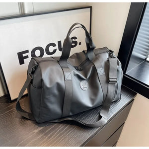 Dark Gray canvas duffel bag with contrast straps and side pockets.
