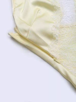Lace-trimmed midi slip dress in pale yellow satin with side zipper detail.