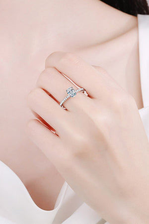 Silver moissanite ring with a solitaire oval stone and pave band.