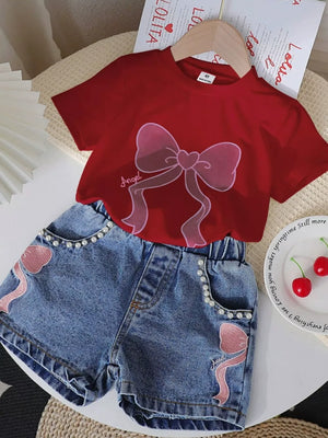 Scarlet tee with bowknot graphic and pearl-trimmed denim shorts with bowknot appliques.