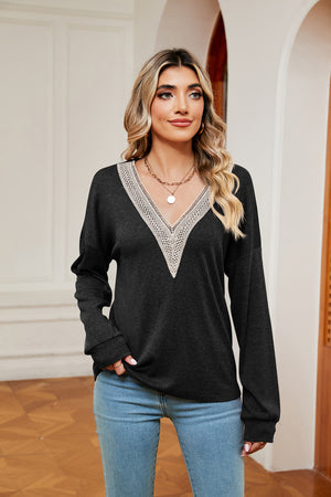 Black relaxed knit sweater with lace-trimmed V-neck and long sleeves