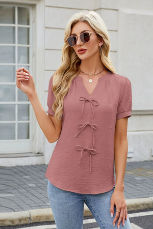 Dusty pink textured blouse with V-neck and three bow-tie details
