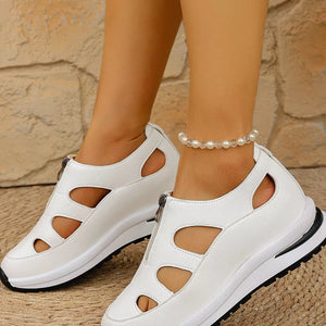 White cutout wedge sneakers with zipper detail and chunky sole.