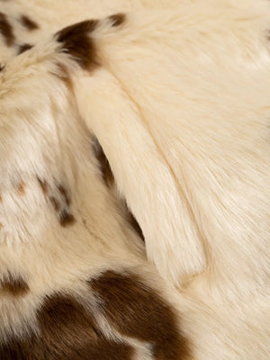 Cropped faux fur jacket in beige with brown spots, showing textured material.