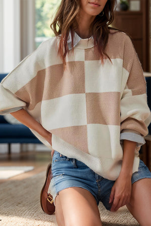 Checkerboard knit oversized sweater in blush-beige and cream with a crew neck and long sleeves.