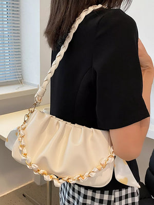 Beige ruched mini shoulder bag with braided strap and gold chain detail.