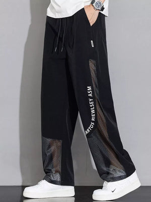 Black sweatpants with wide legs, mesh panels, and graphic text detail.