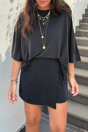 Black tie-wrap skirt and oversized tee set with asymmetric hem detail.