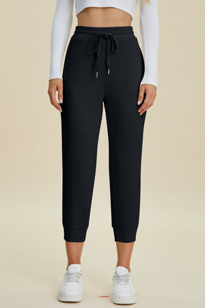 Black joggers with drawstring waist and cuffed ankles.
