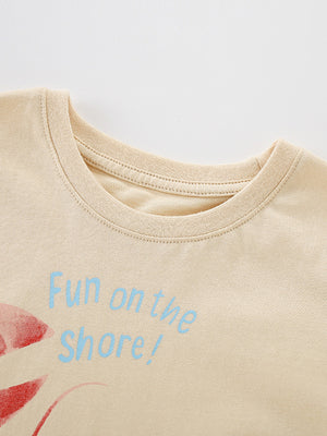 Beige cotton toddler tee with lobster graphic and "Fun on the shore!" text.