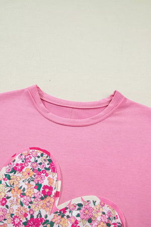 Pink cotton t-shirt with floral heart patch detail and crew neck.