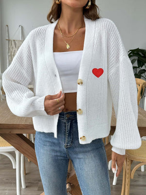 White knit cardigan with balloon sleeves and red heart appliqué, buttoned front.