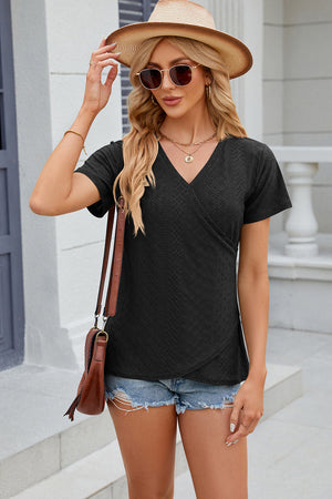 Black eyelet wrap v-neck top with short sleeves and a textured pattern.