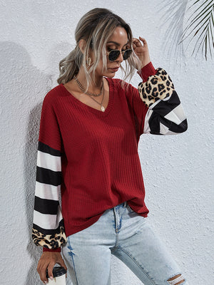 Waffle knit v-neck top in wine with colorblock sleeves featuring leopard print, stripes, and geometric patterns.