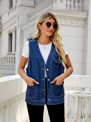 Utility denim vest in medium dark wash with button front and four pockets.