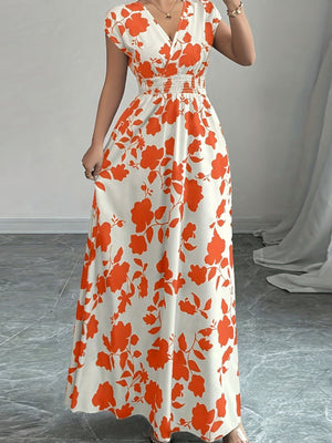 Floral surplice maxi dress with orange-red floral print, V-neck, cap sleeves, and smocked waist.