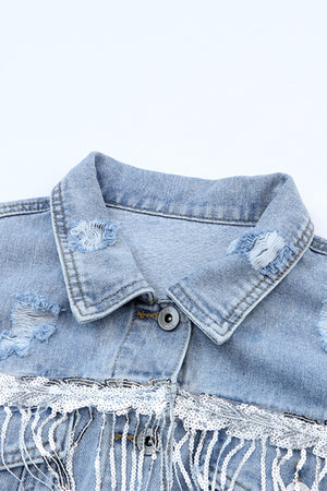 Medium wash denim trucker jacket with distressed details and sequin fringe trim.