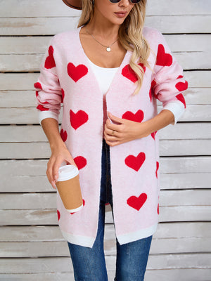 Pink acrylic heart intarsia knit cardigan with white trim and open front.