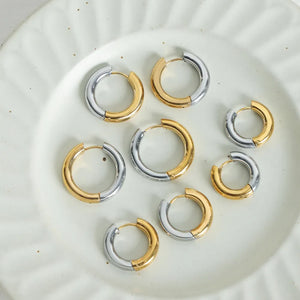 Two-tone segmented hoop earrings in gold and silver with a polished finish.