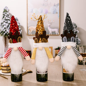 Festive gnome bottle toppers with antlers in red, gold, and dark gray sequin hats and striped sleeves.