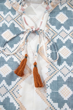 Geometric print blouse with tassel tie detail and ruffled collar.