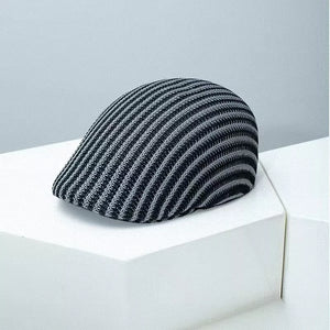 Textured striped flat cap in black and white with a breathable knit design.
