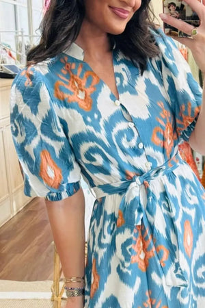 Ikat floral midi dress with puff sleeves, V-neck, button front, and tie waist in blue, white, and orange cotton.