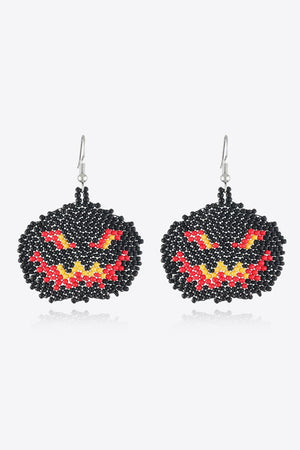 Beaded pumpkin earrings in black with red and yellow jack-o-lantern faces.
