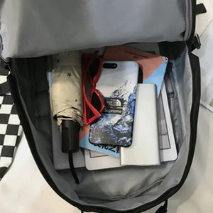 Black backpack interior with umbrella, red sunglasses, phone case, and power bank.