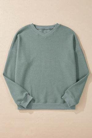 Relaxed sage waffle knit crewneck sweater with long sleeves and ribbed cuffs and hem.