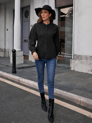 Black blouse with textured ruffle collar, button front, and peplum waist.