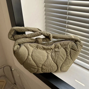 Army green puffy quilted crossbody bag with knotted strap and abstract pattern.