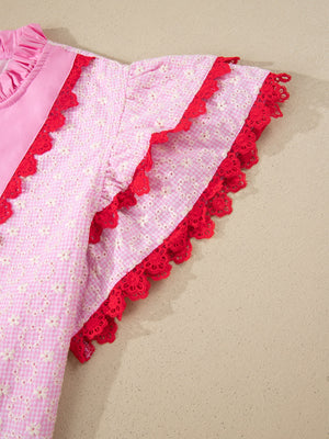 Pink eyelet embroidered blouse with flutter sleeves and red lace trim.