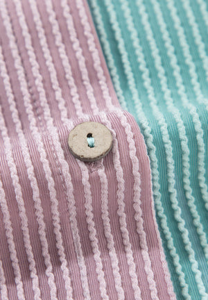 Waffle knit button-up shirt in dusty pink and teal colorblock with a wooden button detail.