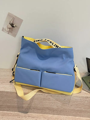 Blue Oxford cloth travel bag with yellow trim and strap, featuring two front zip pockets.
