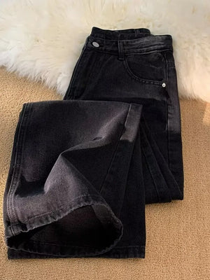 Men's black vintage wash wide-leg jeans with a folded hem detail.