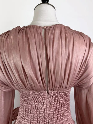 Pink ruffled mini dress with smocked corset waist and button closure detail.