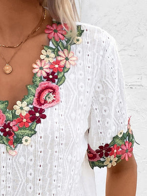 White eyelet peasant blouse with embroidered floral V-neck and sleeves