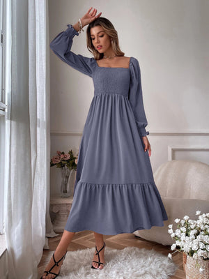 Smocked midi dress in dusty blue with square neck, puff sleeves, and tiered hem.
