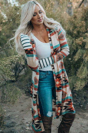 Southwestern print duster cardigan with stripe cuffs and open front, styled with jeans.
