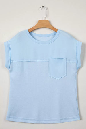 Light blue waffle knit t-shirt with short sleeves, crew neck, chest pocket, and curved hem.